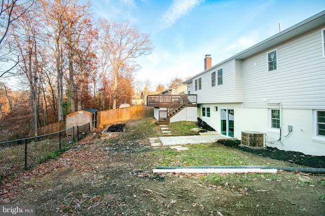 view of yard with a wooden deck, cooling unit, and a storage shed