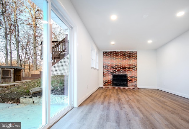 unfurnished living room featuring a fireplace and wood-type flooring