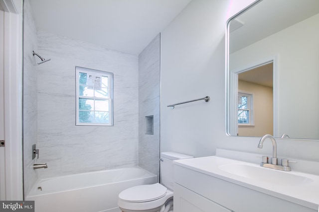 full bathroom featuring vanity, tiled shower / bath combo, and toilet