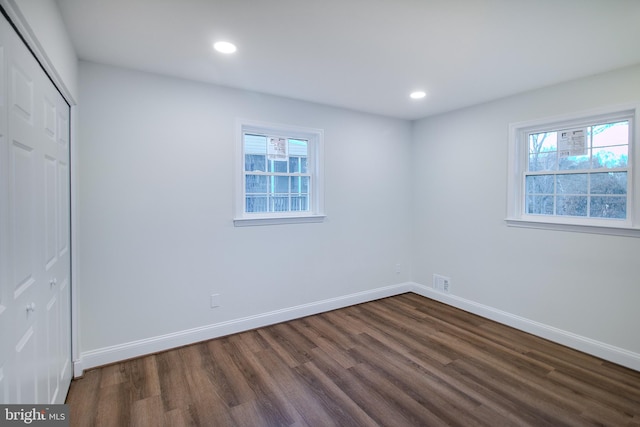 unfurnished bedroom with a closet and dark wood-type flooring