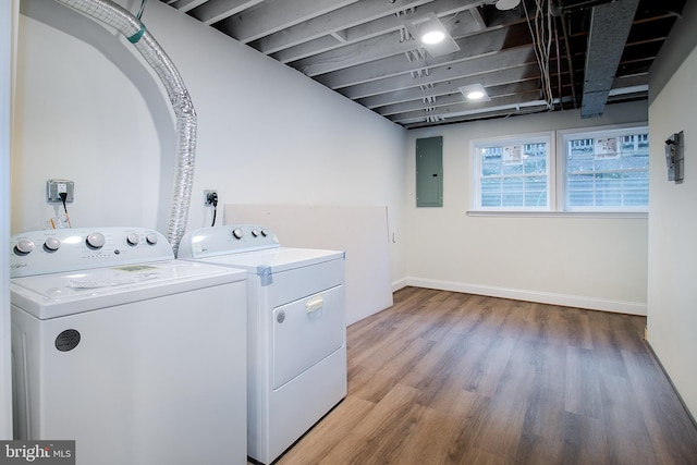 clothes washing area with hardwood / wood-style floors, washer and dryer, and electric panel