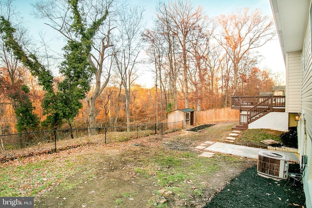 view of yard featuring central AC unit, a storage shed, and a wooden deck