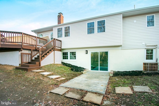 back of house with central AC unit and a wooden deck