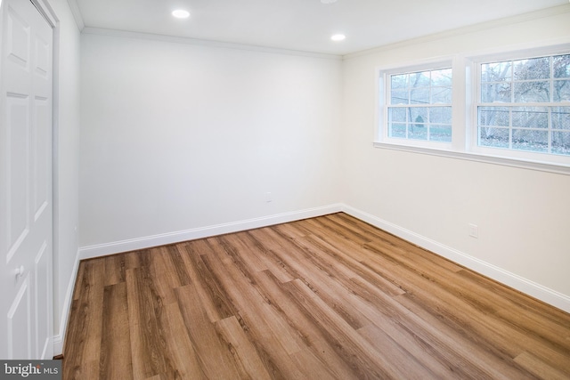 empty room featuring hardwood / wood-style floors and crown molding