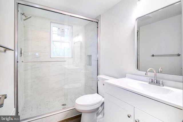 bathroom featuring vanity, toilet, and a shower with shower door