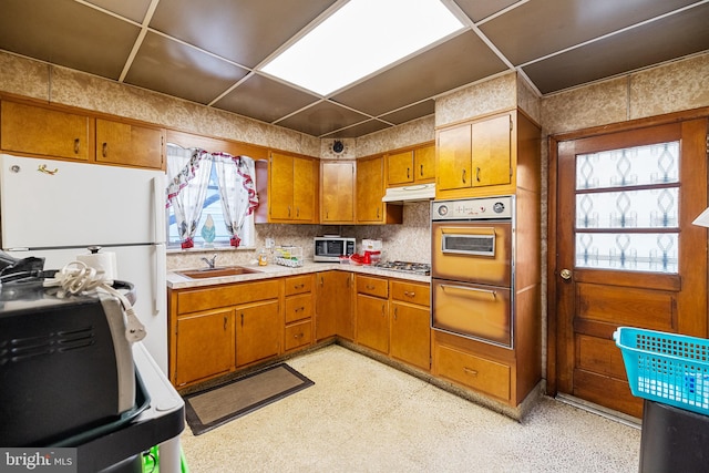 kitchen featuring appliances with stainless steel finishes, a paneled ceiling, and sink