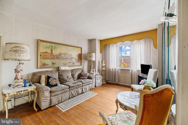 living area featuring hardwood / wood-style floors and a baseboard heating unit