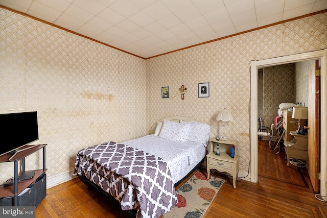 bedroom with dark hardwood / wood-style floors and crown molding