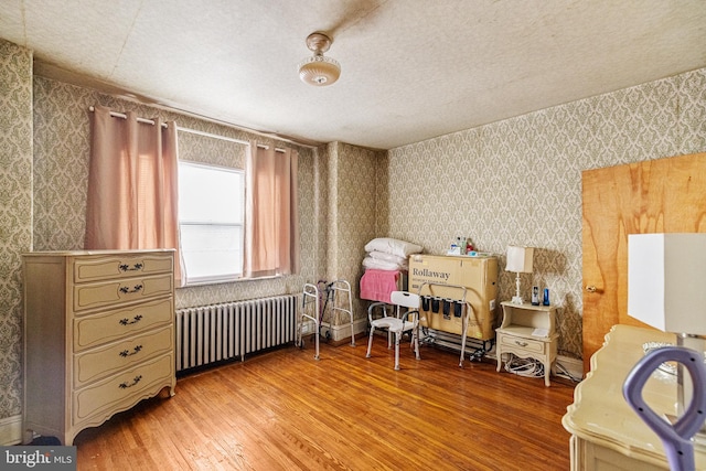 interior space featuring radiator heating unit, hardwood / wood-style floors, and a textured ceiling