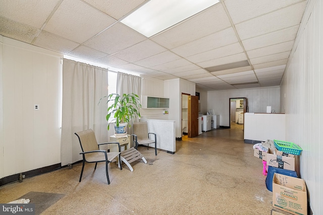 living area with independent washer and dryer and a paneled ceiling