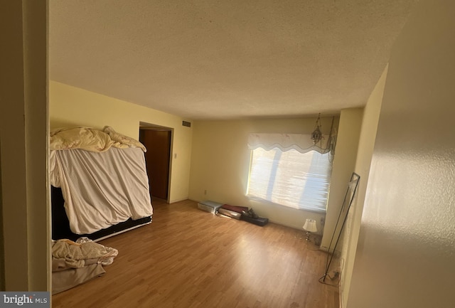 unfurnished bedroom with wood-type flooring and a textured ceiling