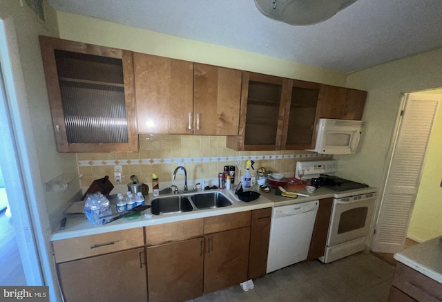 kitchen featuring tasteful backsplash, sink, and white appliances