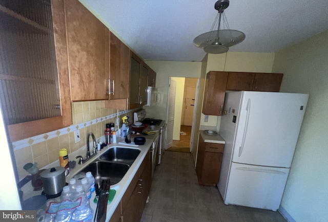 kitchen with tasteful backsplash, sink, decorative light fixtures, and white appliances