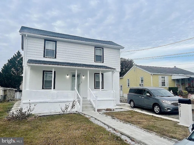 view of front property with covered porch and a front yard