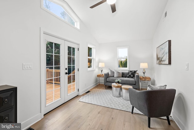 living room featuring ceiling fan, light hardwood / wood-style flooring, high vaulted ceiling, and french doors