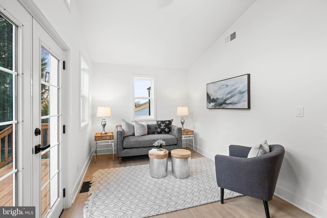 living room with light wood-type flooring and lofted ceiling