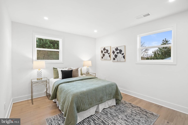 bedroom featuring light hardwood / wood-style floors and multiple windows