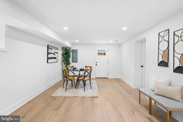 dining room featuring electric panel and light hardwood / wood-style flooring