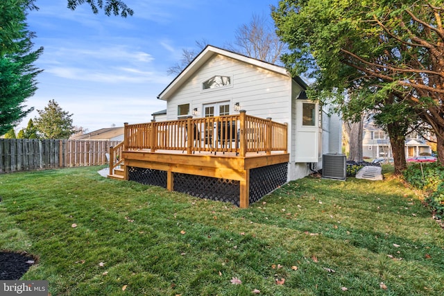 rear view of property featuring a lawn, cooling unit, and a deck