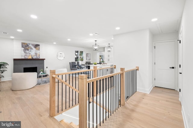 hallway with light wood-type flooring and sink