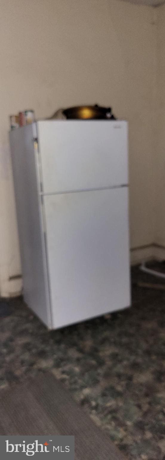 details with dark colored carpet and white refrigerator