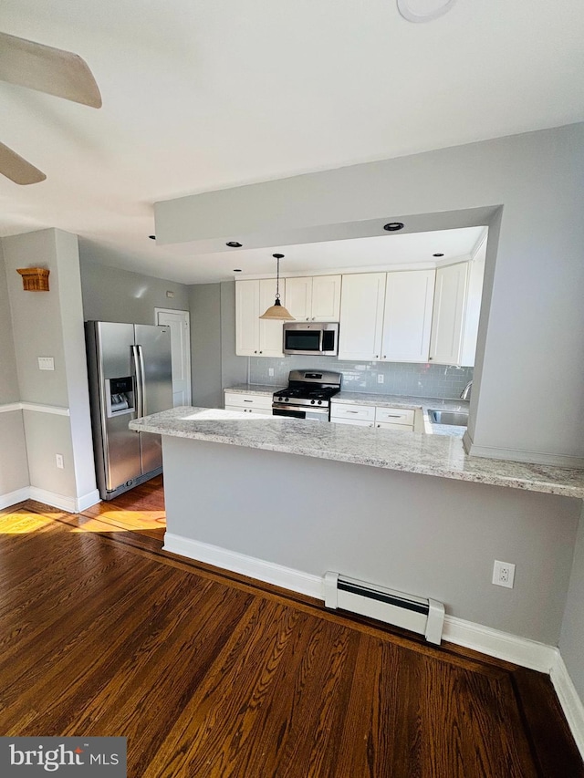 kitchen featuring kitchen peninsula, light stone countertops, stainless steel appliances, baseboard heating, and white cabinets