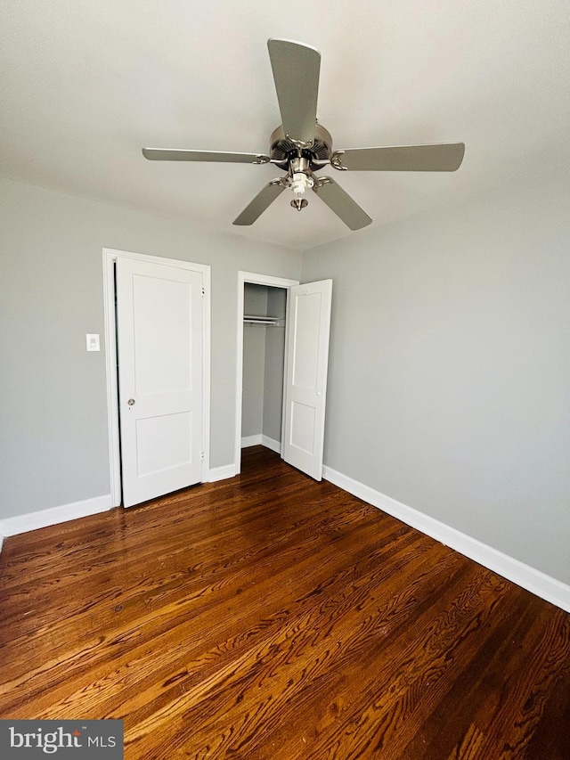 unfurnished bedroom featuring a closet, ceiling fan, and dark hardwood / wood-style flooring