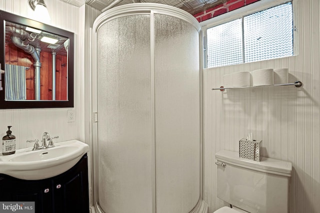 bathroom with wood walls, vanity, an enclosed shower, and toilet