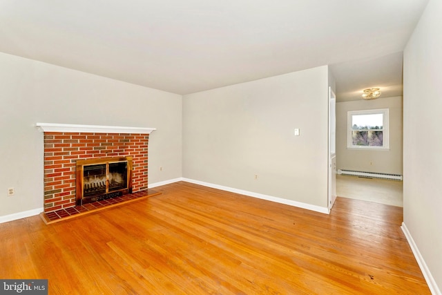 unfurnished living room with a fireplace, hardwood / wood-style floors, and baseboard heating