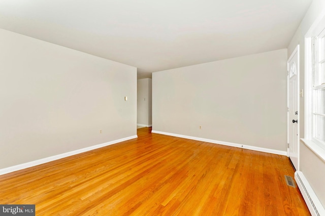 unfurnished room with a baseboard radiator and wood-type flooring