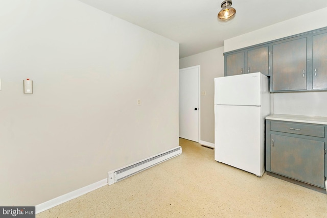 kitchen with white fridge and a baseboard radiator