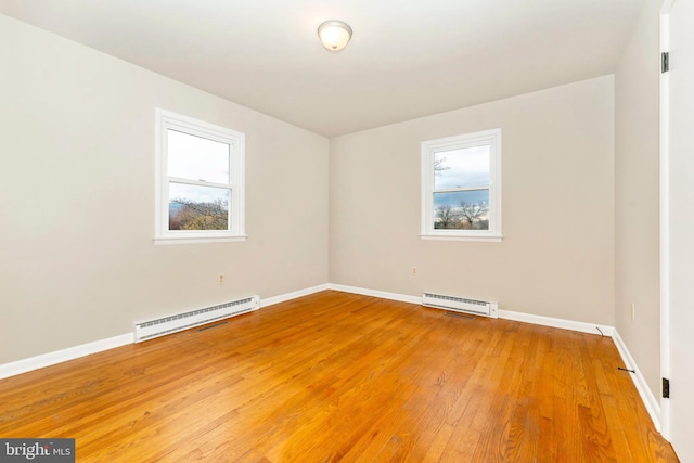 empty room with baseboard heating and wood-type flooring