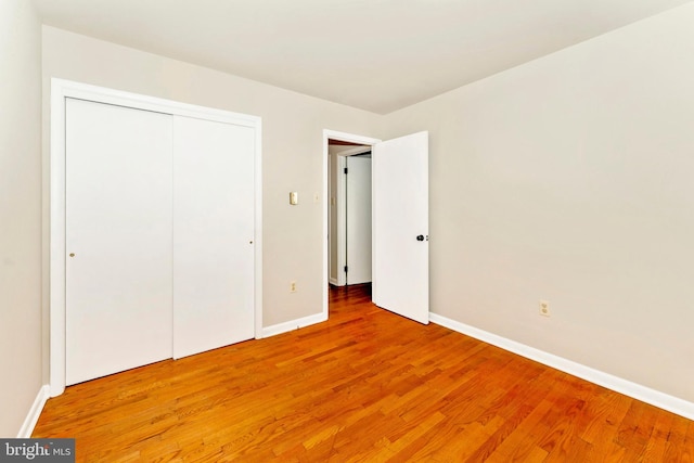 unfurnished bedroom featuring a closet and hardwood / wood-style floors