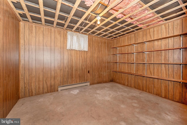 basement featuring wooden walls and a baseboard radiator