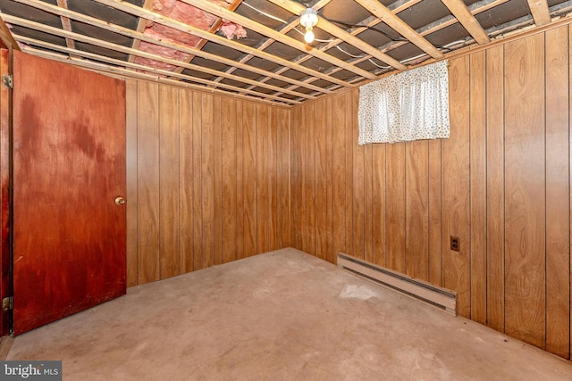 basement featuring baseboard heating and wood walls