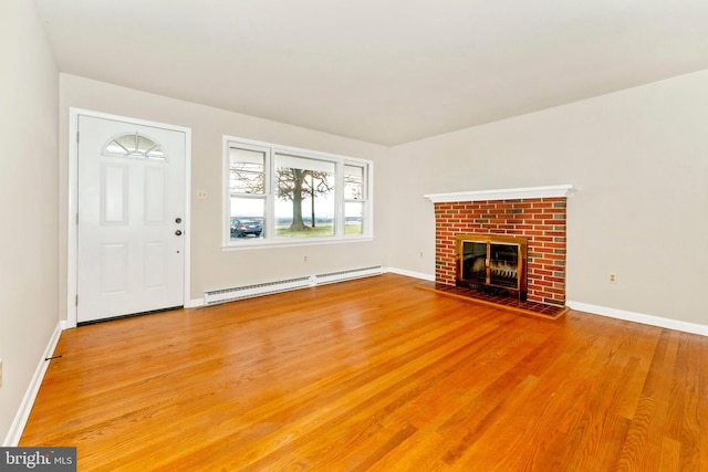 unfurnished living room with a fireplace, a baseboard radiator, and hardwood / wood-style flooring