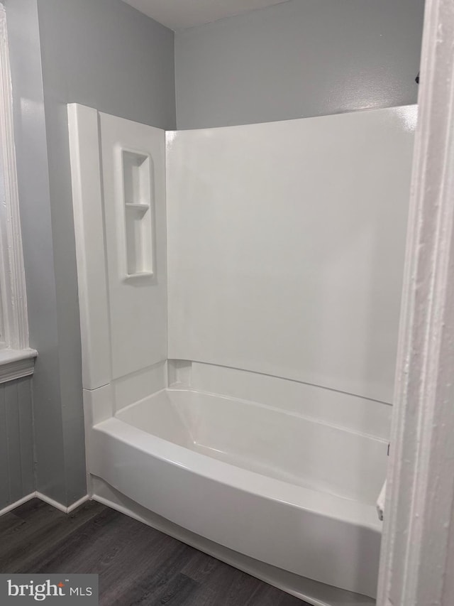 bathroom featuring wood-type flooring and a tub to relax in