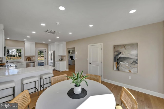 dining room featuring light hardwood / wood-style flooring and sink