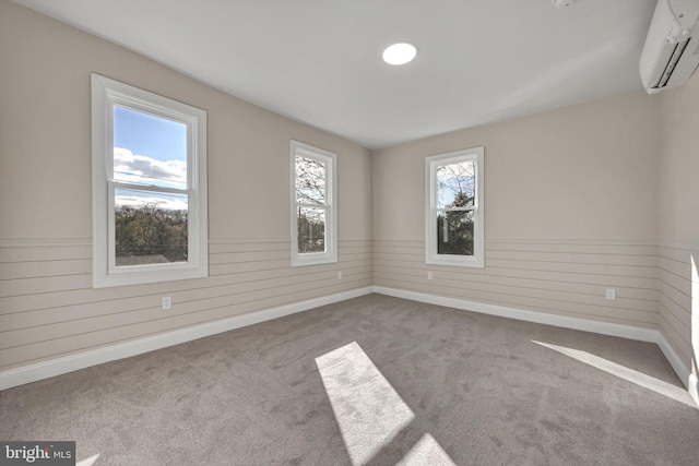 spare room featuring light colored carpet, wooden walls, and a wall mounted AC