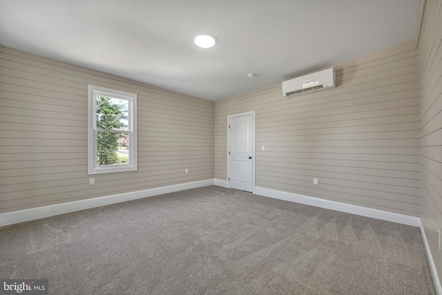 empty room featuring an AC wall unit, wood walls, and carpet floors