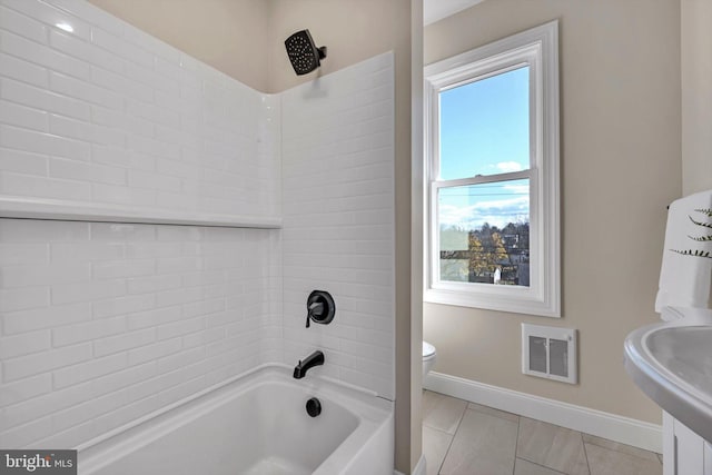 full bathroom featuring tile patterned floors, tiled shower / bath combo, toilet, and sink