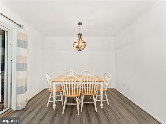 dining area with ornamental molding, dark wood-type flooring, and a chandelier