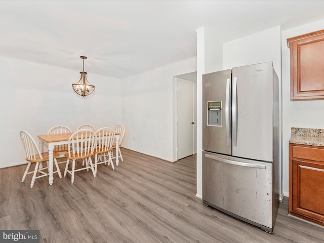 dining area with a notable chandelier and light hardwood / wood-style floors