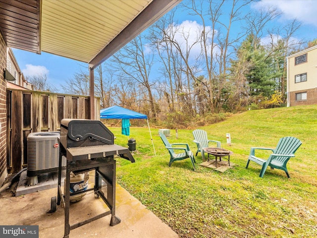 view of yard with central AC, a patio, and a fire pit