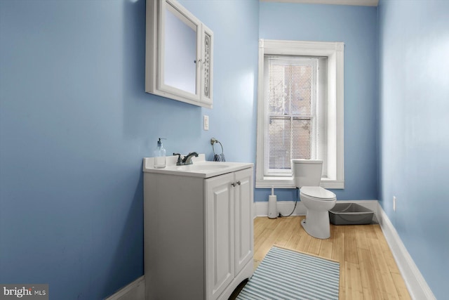 bathroom with hardwood / wood-style flooring, vanity, and toilet