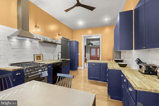 kitchen featuring wood counters, exhaust hood, blue cabinets, light hardwood / wood-style flooring, and high end stove