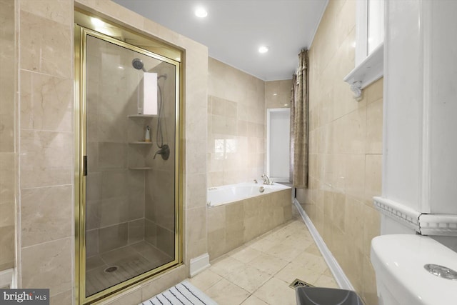 bathroom with tile patterned floors, separate shower and tub, and tile walls