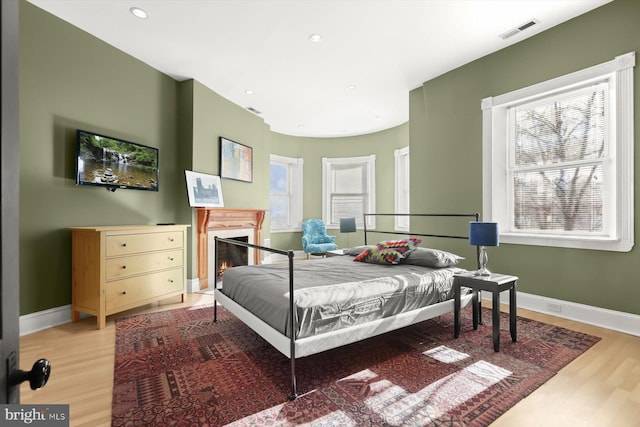 bedroom featuring hardwood / wood-style flooring and multiple windows