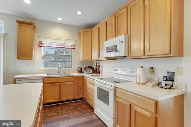 kitchen featuring white appliances, dark wood-type flooring, light countertops, a sink, and recessed lighting