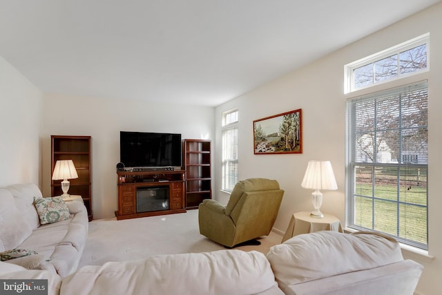 carpeted living room with a glass covered fireplace